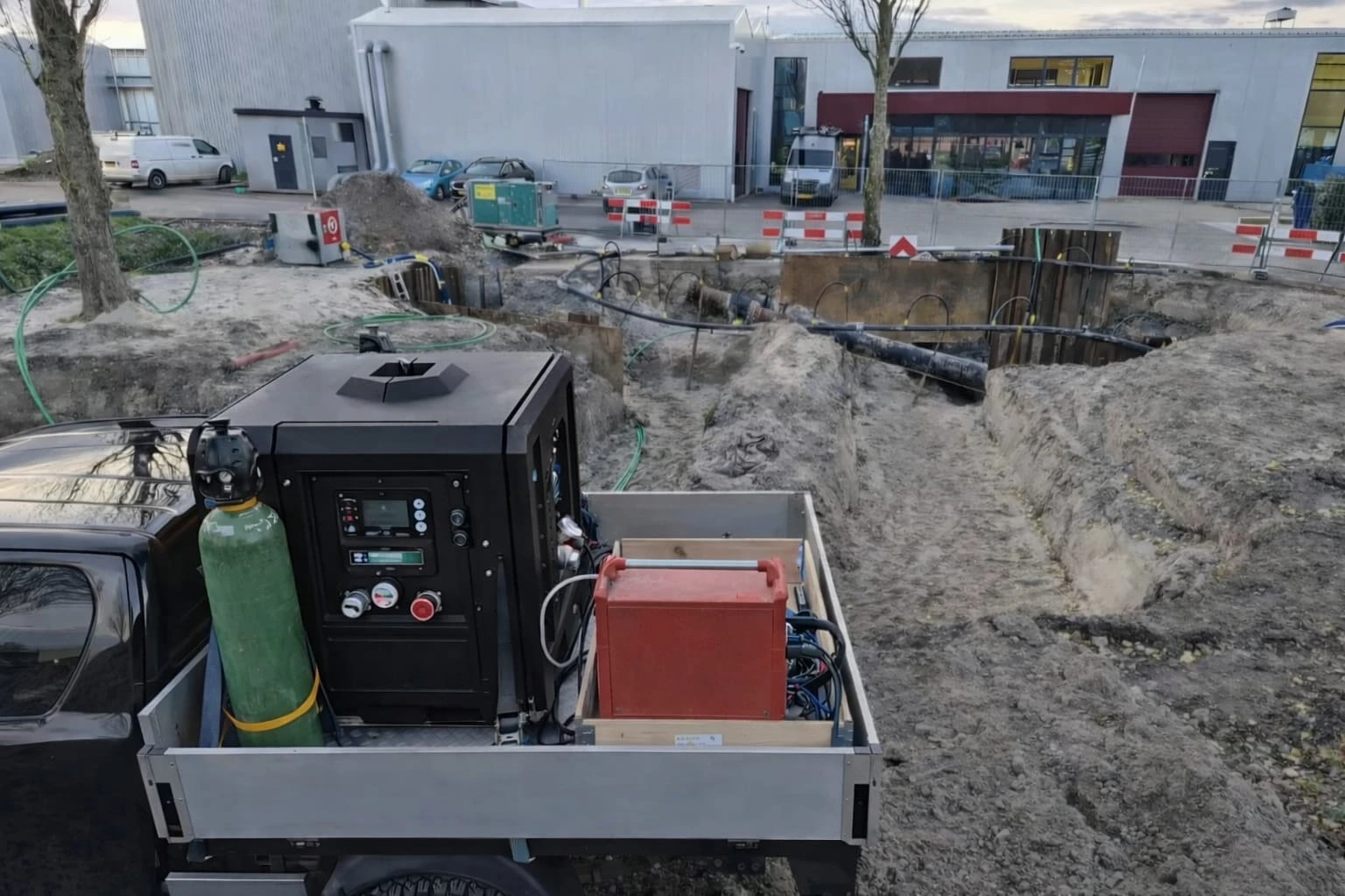 Werkterrein met sleuf en mobiele installatie op een pick-up